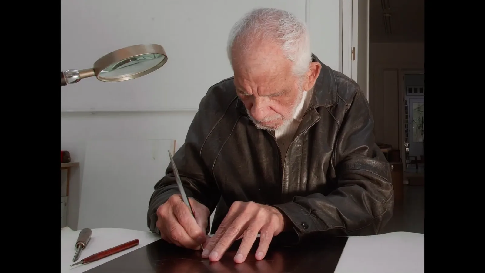 Julio Zachrisson at his desk, cutting the plate